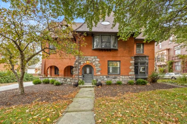 Historic 1870s house framed by trees.